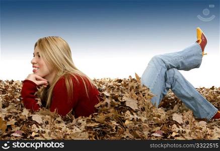 Beautiful young Hispanic woman laying in leaves. Legs on backwards.