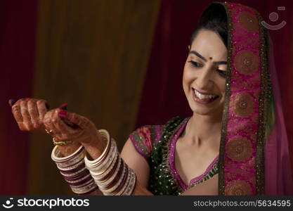 Beautiful young Indian bride looking at her bangles
