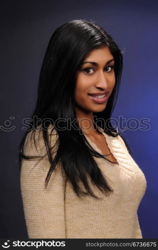 Beautiful young Indian woman in a beige knit blouse