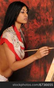 Beautiful young Indian woman working on a canvas