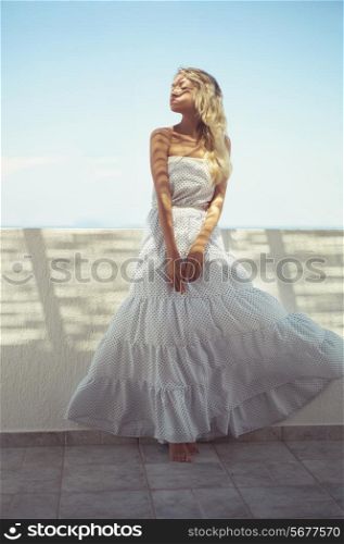 Beautiful young lady in white dress in the sunlight