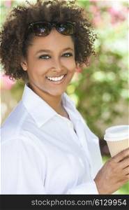Beautiful young mixed race black African American woman smiling wearing sunglasses drinking a takeaway cup of coffee outside