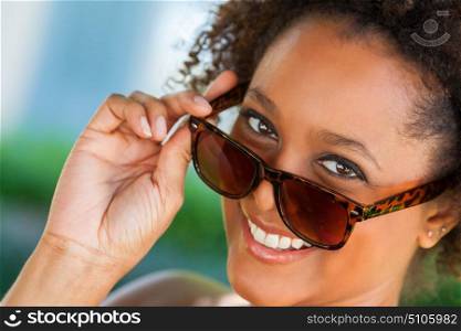 Beautiful young mixed race black African American woman smiling with perfect teeth and wearing sunglasses