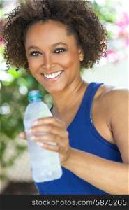 Beautiful young mixed race black African American woman with perfect teeth, smiling, exercising and drinking a bottle of water outside