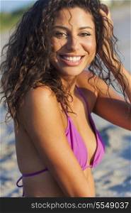 Beautiful young mixed race sexy Hispanic woman in bikini laughing on a deserted tropical beach