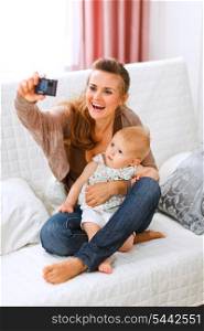 Beautiful young mom making photos with her lovely baby at home&#xA;