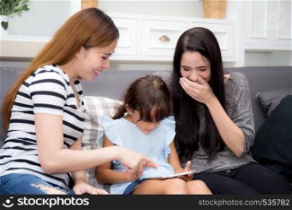 beautiful young mother, aunt and kid having time together with smile and happy learning on digital tablet in the living room at home, family activity concept.