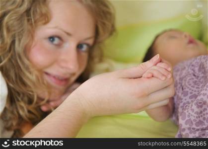 beautiful young mother hold small children hand