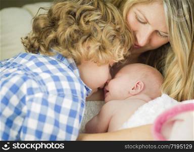 Beautiful Young Mother Holds Precious Newborn Baby Girl as Brother Looks On.