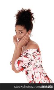 Beautiful young multi-racial woman standing in a summer dress, in a close up image, smiling, looking surprised and flirting, with her hair in a bun isolated for white background