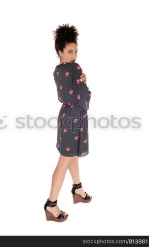 Beautiful young multi-racial woman standing in full length in a black printed dressing profile with black hair in a bun, isolated for white background