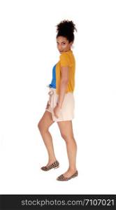 Beautiful young multi-racial woman standing in shorts and a yellow sweater in profile fore white background