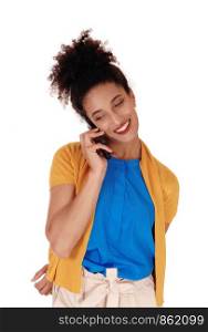 Beautiful young multi-racial woman standing in shorts holding her cellphone in her hand and having a pleasant talk, isolated forwhite background