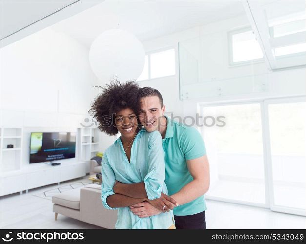 Beautiful young multiethnic couple hugging in their new apartment