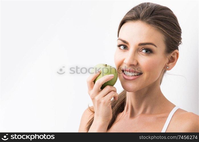 Beautiful young nude woman with green apple close up on white background. Perfect woman with apple