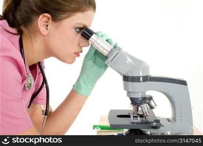 Beautiful young nurse looking into microscope.