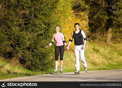 Beautiful young people rollerblading at a spring afternoon