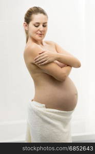 Beautiful young pregnant woman having posing in bathroom