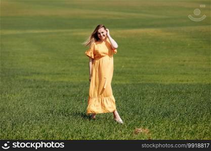 Beautiful young pregnant woman in long dress in the green field on summer day. Happy maternity and pregnancy concept.. Beautiful young pregnant woman in long dress in the green field on summer day. Happy maternity and pregnancy concept