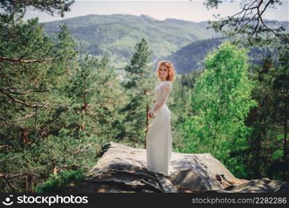 beautiful young red-haired bride in the forest with a floral wreath on her head. woman in long white dress outdoors on summer day. wedding day.. beautiful young red-haired bride in the forest with a floral wreath on her head. woman in long white dress outdoors on summer day. wedding day