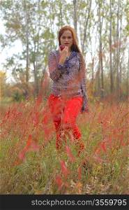 Beautiful young redhead in a autumn meadow