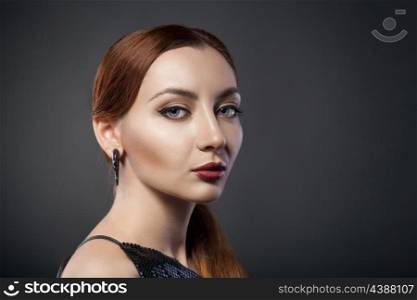 beautiful young redhead woman isolated on dark background with copyspace