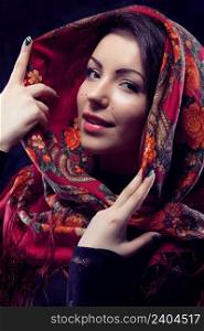 Beautiful young russian woman wearing red traditional russian shawl on black background