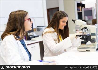 Beautiful young scientists working at the laboratory