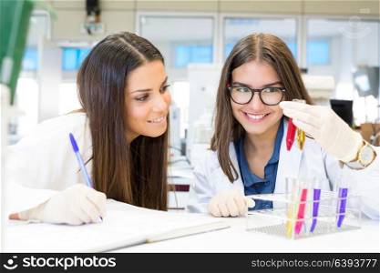 Beautiful young scientists working at the laboratory