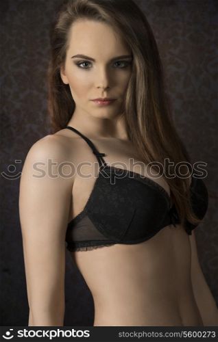 Beautiful, young, sensual woman with long, straight, brown hair, dark make up, wearing sexy, balck lingerie.