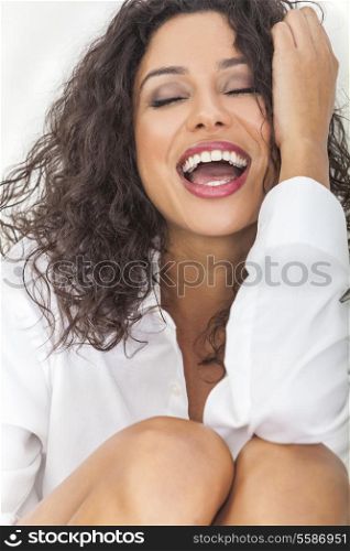 Beautiful young sexy happy Latina Hispanic woman with perfect teeth open mouthed laughing in ecstasy