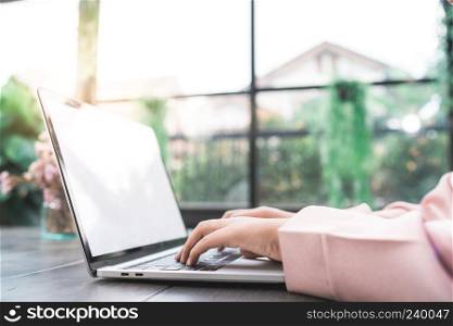 Beautiful young smiling asian muslim woman working on laptop sitting in living room at home. Asian business woman working document finance and calculator in her home office. Enjoying time at home.