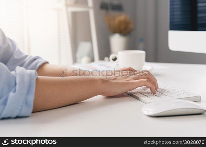 Beautiful young smiling asian woman working on laptop while sitt. Beautiful young smiling asian woman working on laptop while sitting in a living room at home. Asian business woman working in her home office. Enjoying time at home.