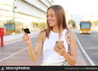 Beautiful young smiling woman with smartphone and credit card by the airport. Happy girl with suitcase after arrived airplane booking and paying for hotel. summer vacation. new abroad journey travel.. Beautiful young smiling woman with smartphone and credit card by the airport. Happy girl with suitcase after arrived airplane booking and paying for hotel. summer vacation. new abroad journey travel