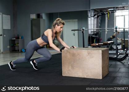 Beautiful young sports woman doing push ups on fit box at gym at fitness center. Beautiful young sports woman doing push ups on fit box at gym