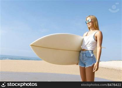 Beautiful young surfer girl checking the waves