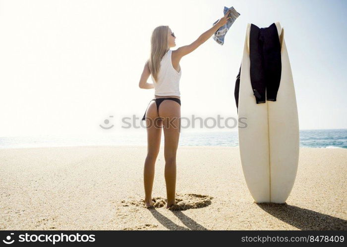Beautiful young surfer girl getting ready to surf
