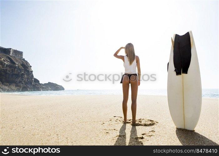 Beautiful young surfer girl getting ready to surf