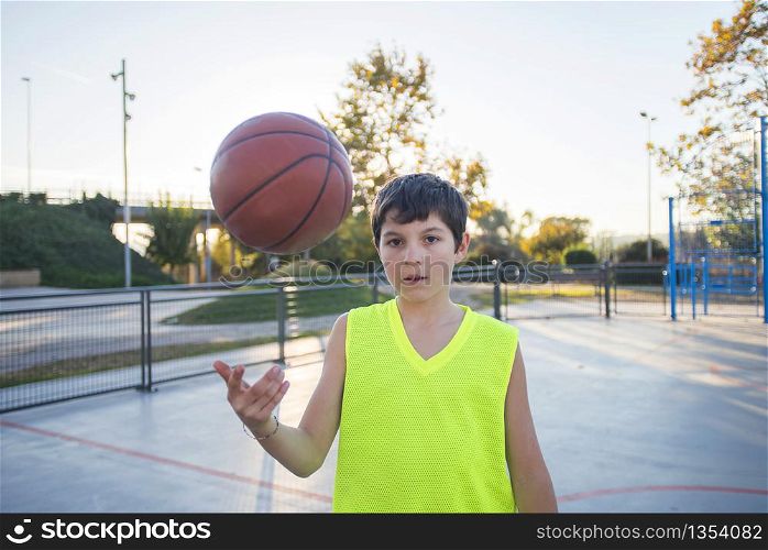 Beautiful young teen model wearing a yellow sleeveless and holding the ball on the court