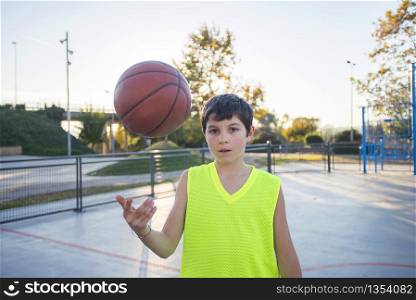 Beautiful young teen model wearing a yellow sleeveless and holding the ball on the court