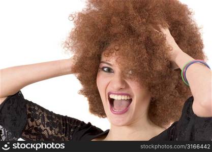 Beautiful young teenager screaming while holding her red afro wig