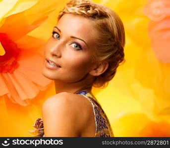 Beautiful young woman among big yellow flowers