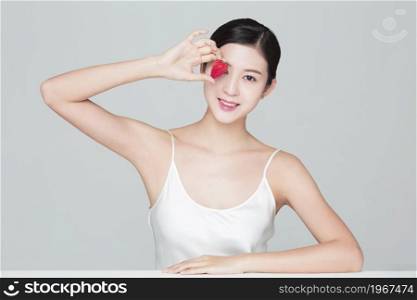 Beautiful young woman and a strawberry