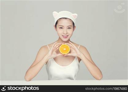Beautiful young woman and an orange