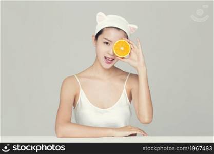 Beautiful young woman and an orange