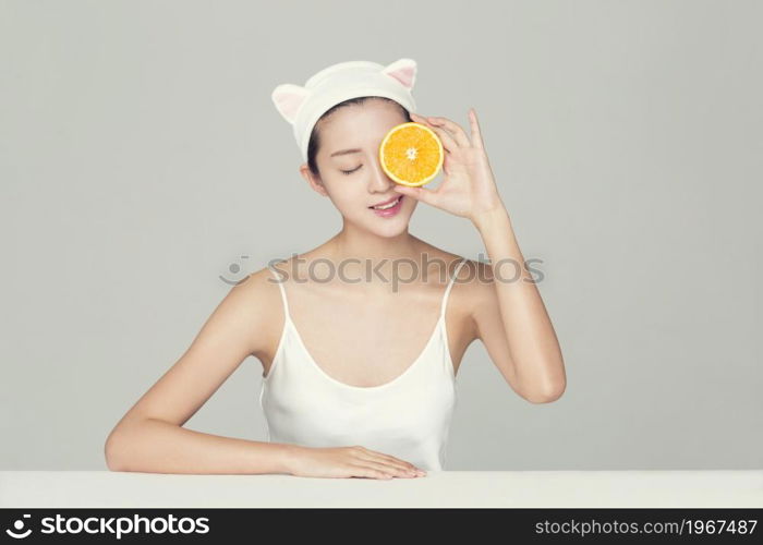 Beautiful young woman and an orange