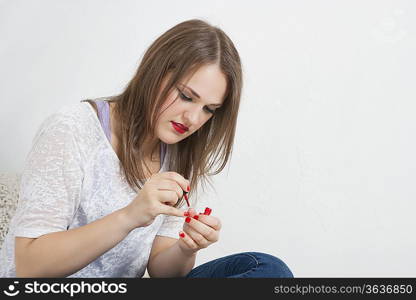 Beautiful young woman applying nail paint