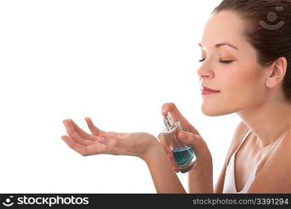 Beautiful young woman applying perfume on her wrist