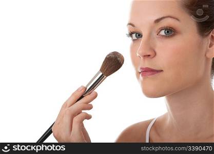 Beautiful young woman applying powder with brush