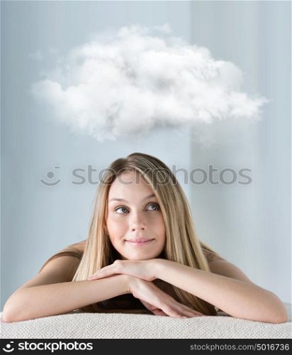 Beautiful young woman at a spa salon dreaming with thoughts cloud overhead